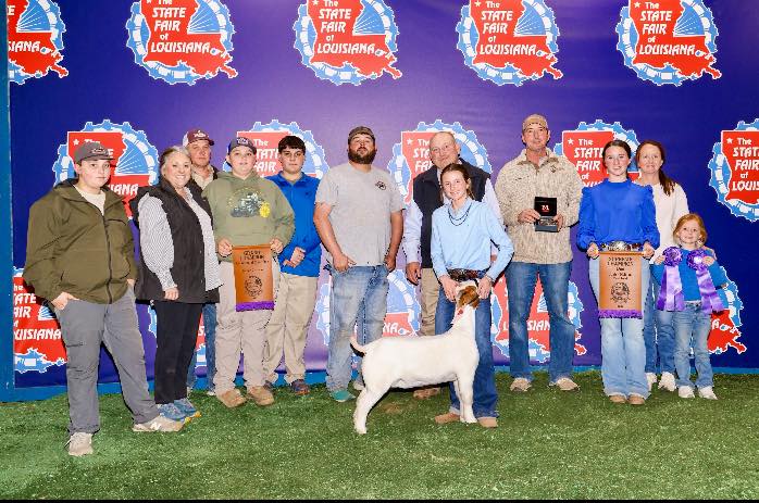 A group of people with a white goat.